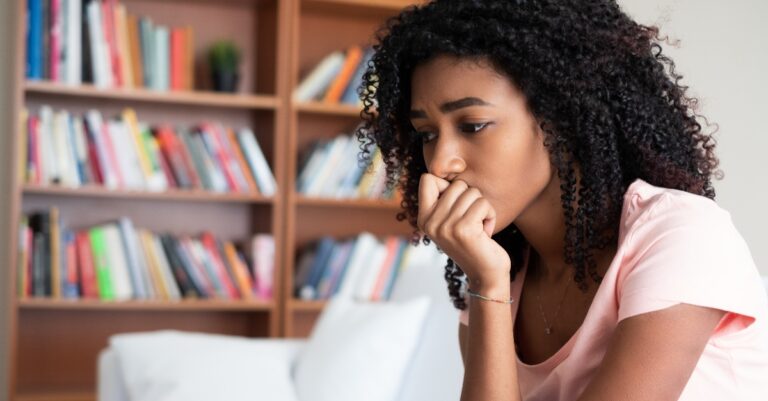 Sad woman lying on the couch at home feeling bad